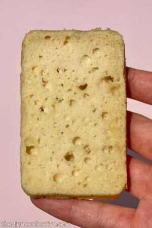 Close-up of a rectangular white cake slice with an airy crumb and many small holes